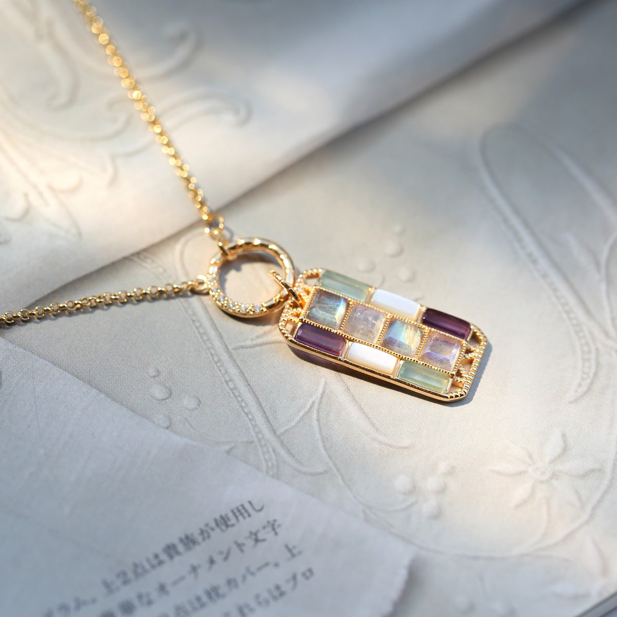 Necklace with a multicolored pendant on a textured surface