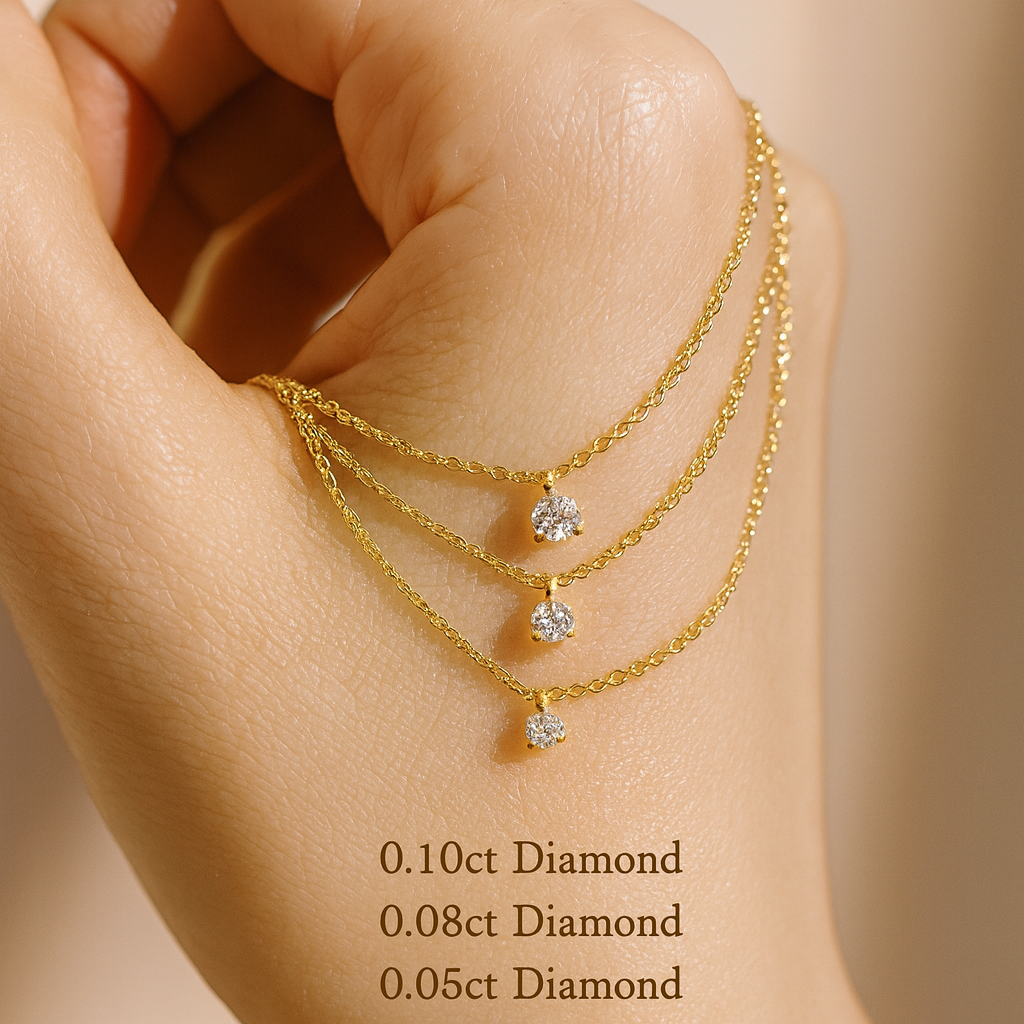 Gold necklace with diamond pendants on a hand against a beige background