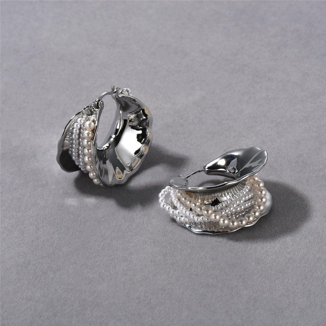 Pair of silver hoop earrings with pearl accents on a gray background