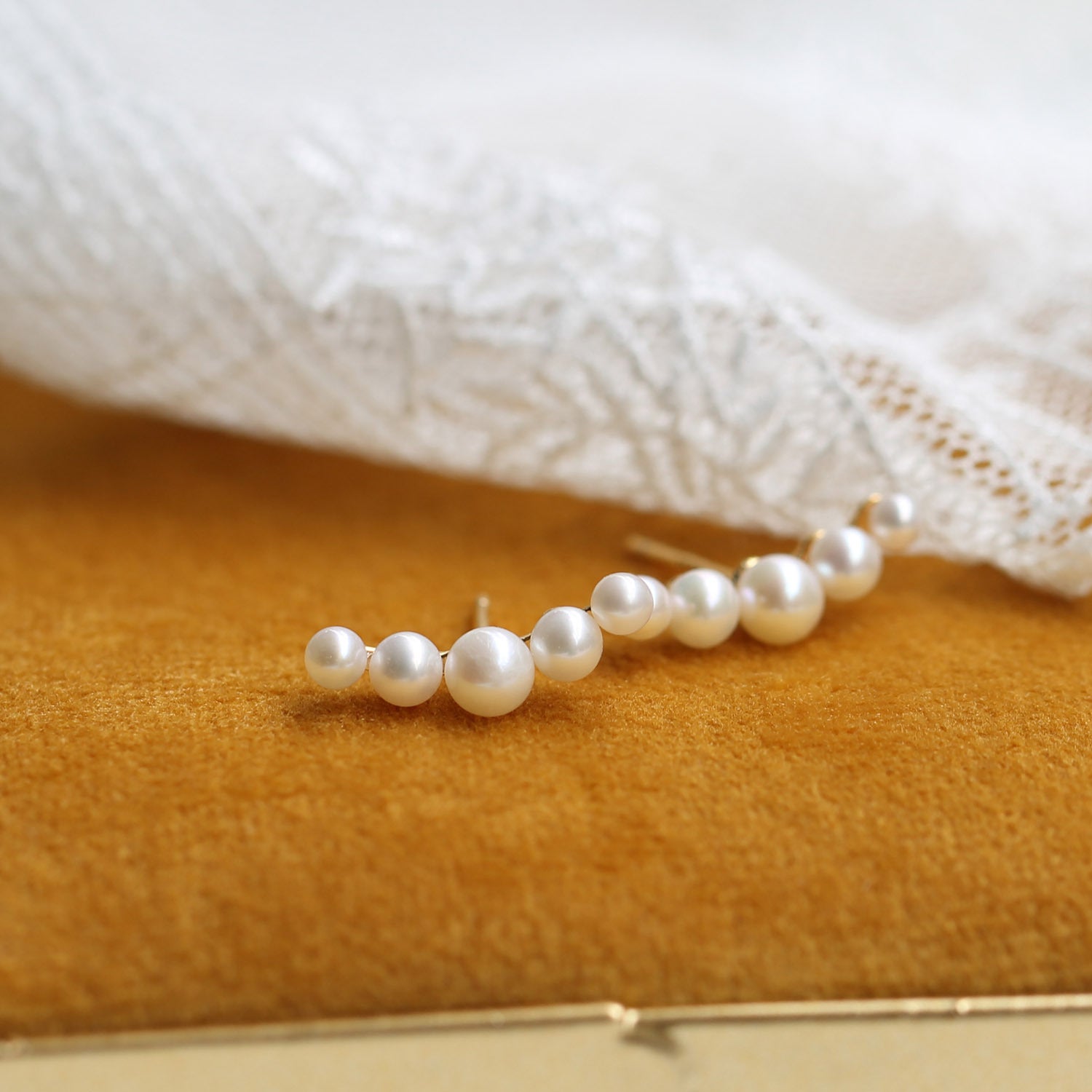 Pearl earring on a textured surface by Gembee Jewellery