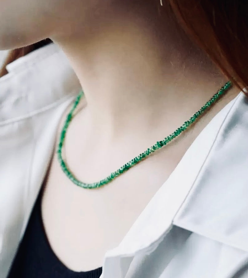 Person wearing a green Tsavorite Beaded Necklaceb with a white shirt