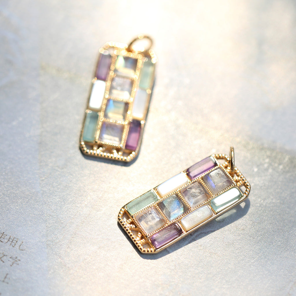 Multicolored gemstone pendants on a soft fabric background