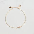 Gold bracelet with small stones on a light gray background from the GemBee Jewellery.
