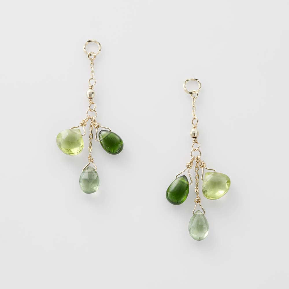 Pair of green teardrop earrings on a white background