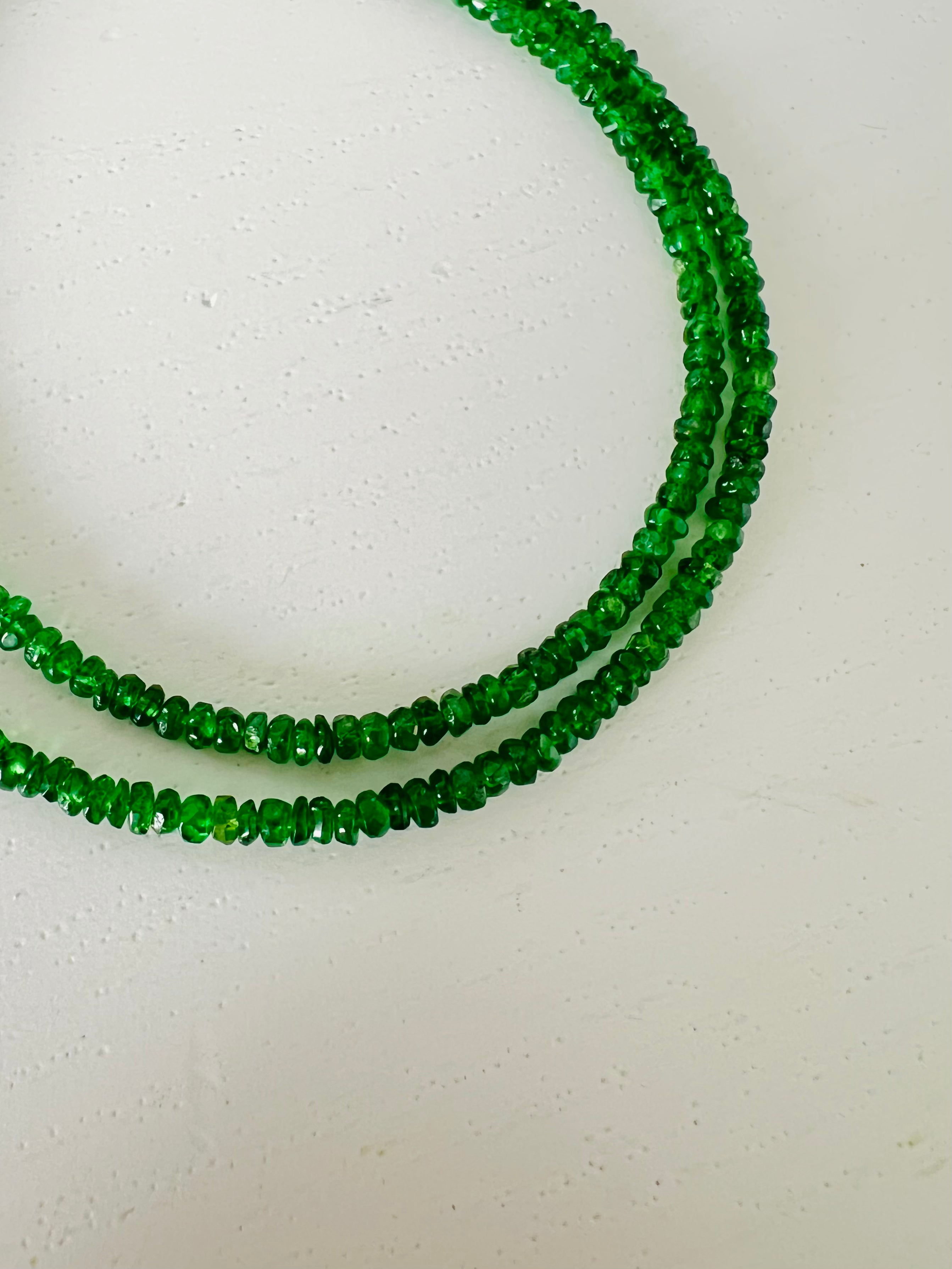 Green beaded necklace on a white background