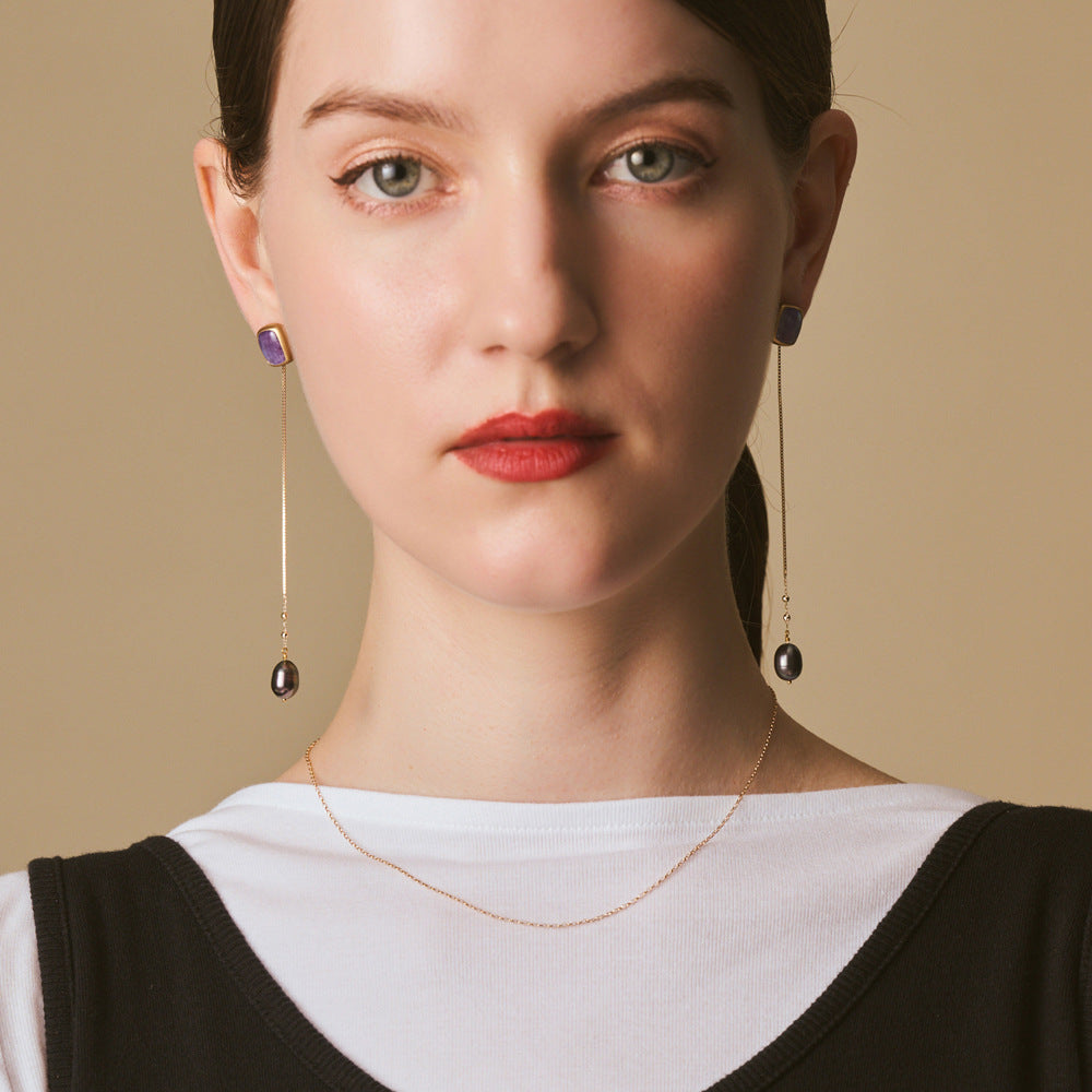 Close-up of a woman wearing earrings with a beige background