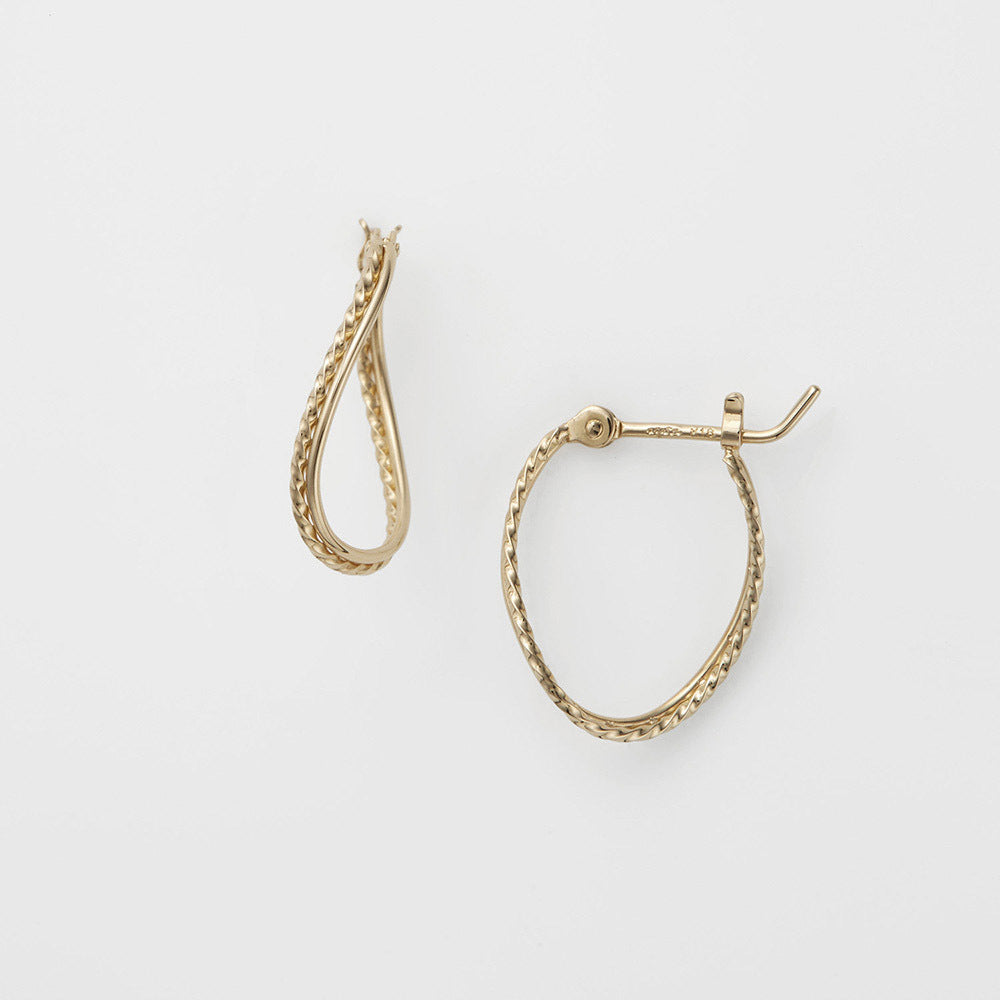 Gold hoop earrings on a light gray background
