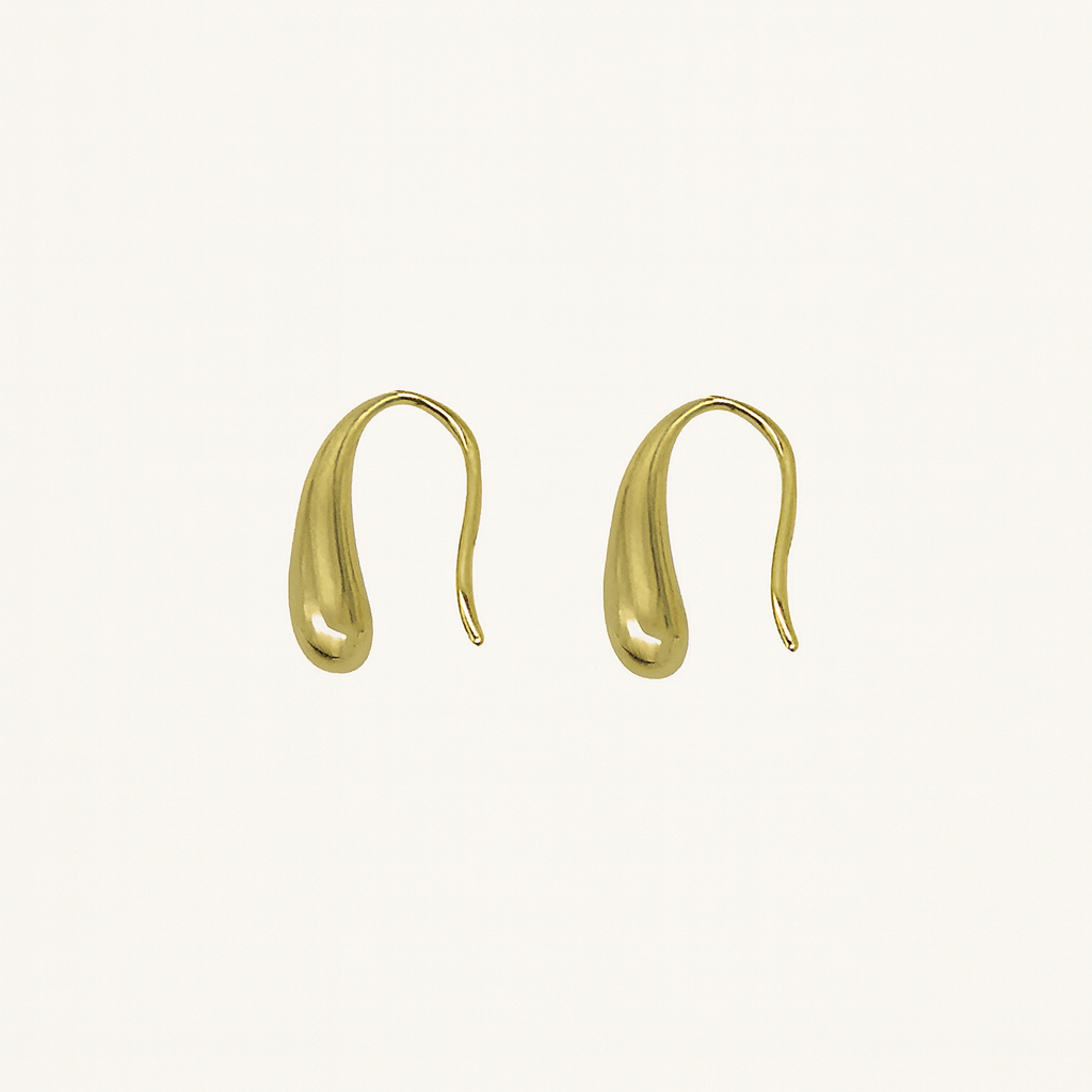 Gold earrings on a light beige background  From Gembee Jewellery