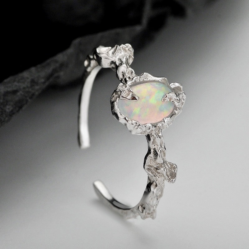 Silver earring with a oval opal stone on a gray background from Gembee Jewellery