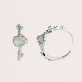 Pair of silver earrings with opal stones on a light pink background from Gembee Jewellery